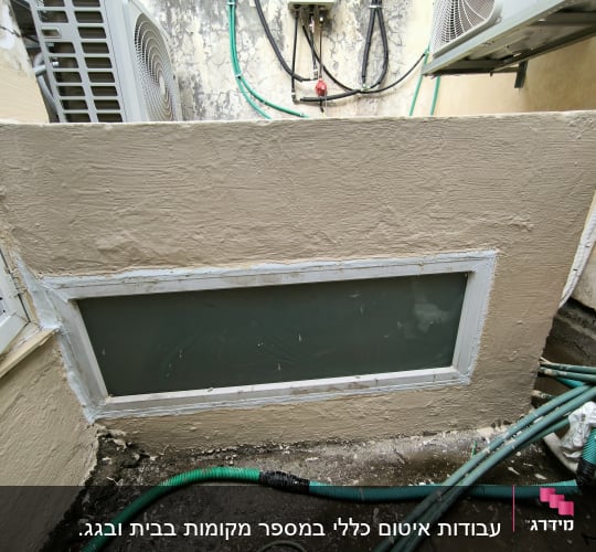 חלון אטום עם מסגרת לבנה וקירות מטויחים